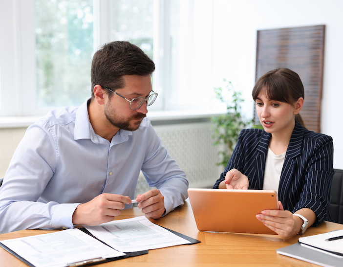 Customer consultant working with client at table in office