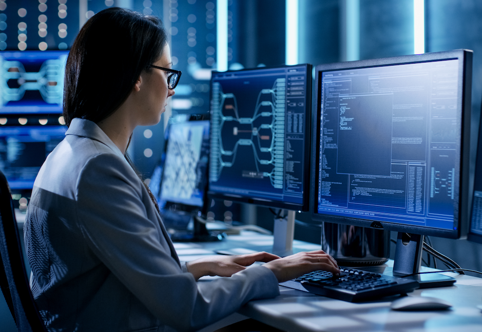Female Data Engineer Reviewing Code on Monitor