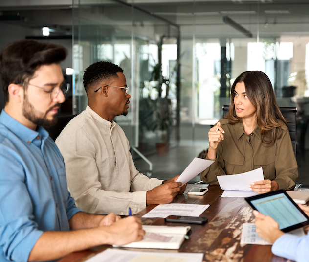 Financial controller sitting at conference table and talking to finance team